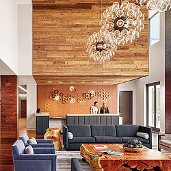 A room with a couch and a table with a chandelier.