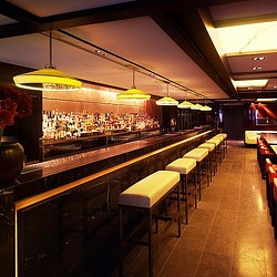 A bar with stools and a bar with lights.