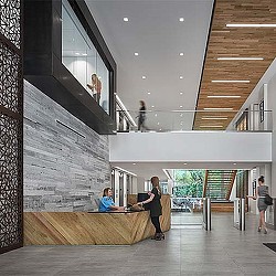 A woman and a man in a room with a wood floor and a glass wall with a glass.