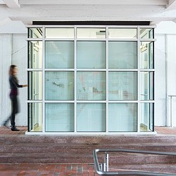 A person standing in front of a glass door.