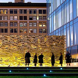 A group of people walking on a walkway between buildings.