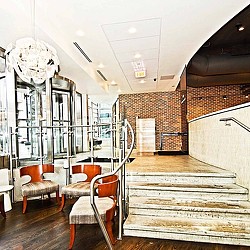 A room with a staircase and chairs.