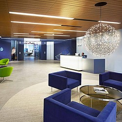 A room with blue chairs and a chandelier.