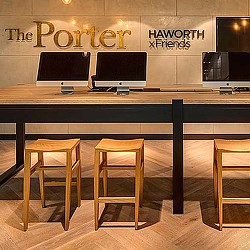 A desk with a computer and chairs.