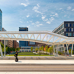 A person riding a bicycle under a bridge.