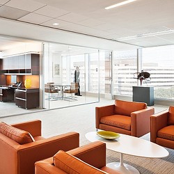 A room with a table chairs and a glass wall.