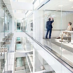 A man and a woman in a glass office.