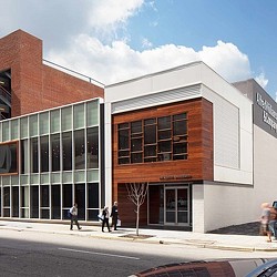 A few people walking outside of a building.