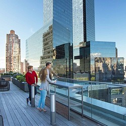 A man and woman walking on a bridge over a city.