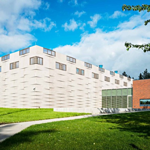 A white building with a green lawn.