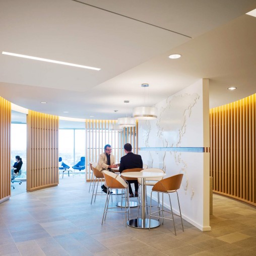 A couple of people sitting at a table in a room with a large window.