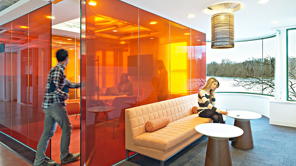 A man and a woman in a room with a glass wall and a window with a view of.