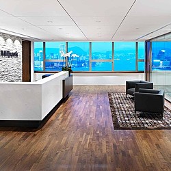 A room with a couch and a table with a rug and a window.