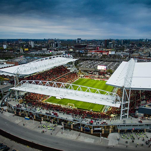 A stadium with a field and a crowd of people.