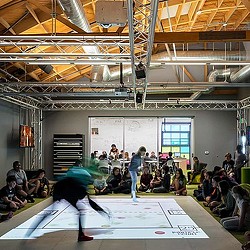 A group of people watching a person do a stunt on a skateboard.