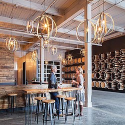 A couple of people standing in a room with a table and chairs.