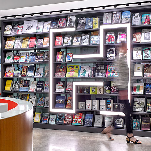 A person standing in front of a shelf of video games.