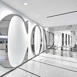 A modern looking room with a large white circular mirror.