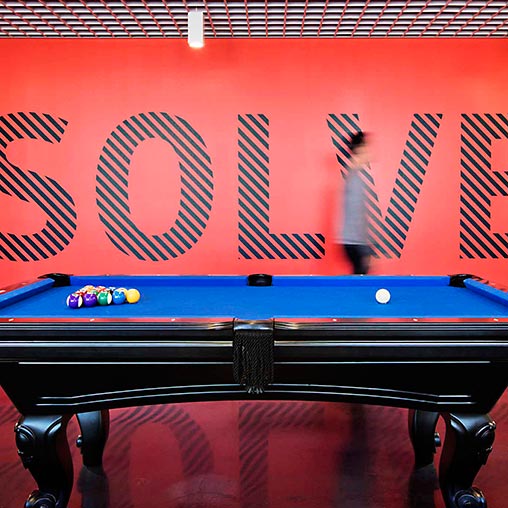 A pool table with a sign above it.