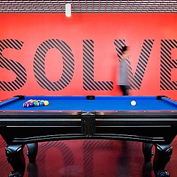 A pool table with a sign above it.