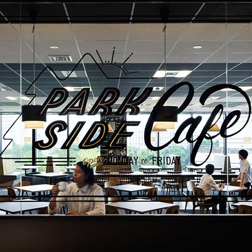A group of people sitting at a table with a sign above them.