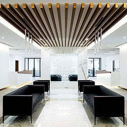 A room with black couches and a fireplace.