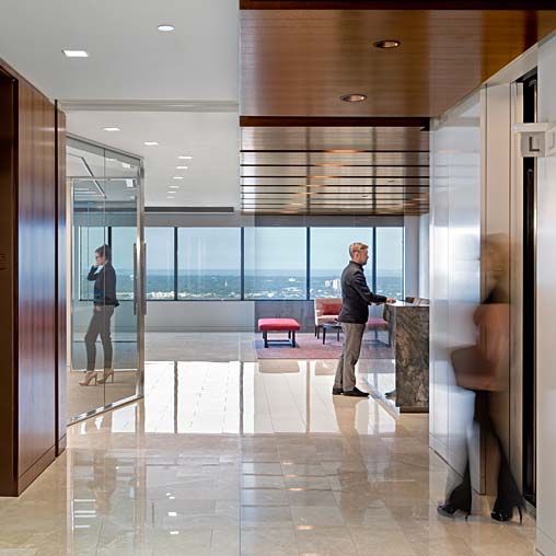 A man and woman standing in a room with glass doors.