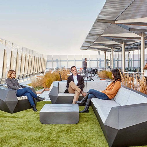 A group of people sitting on couches outside.
