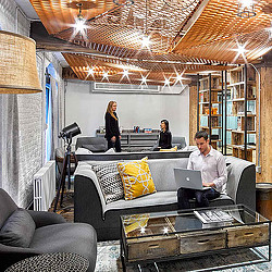 A man and a woman in a room with a laptop.