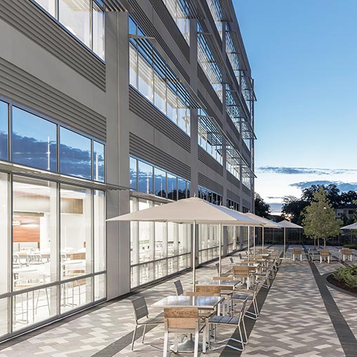 A building with tables and chairs outside.