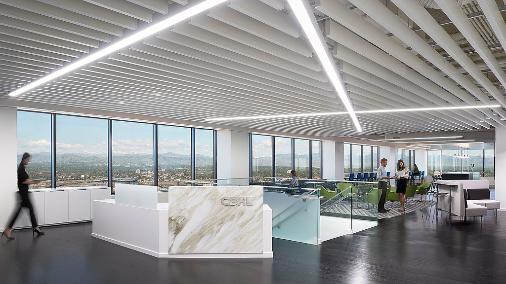A group of people in a room with large windows and a large white table with a white rectangular.