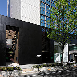 A building with a tree in front.