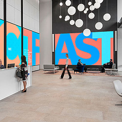 A person standing in front of a large screen.