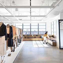 A person sitting on a couch in a room with a large window.