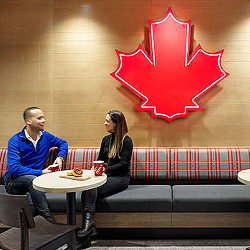 A man and a woman sitting at a table with food and drinks.