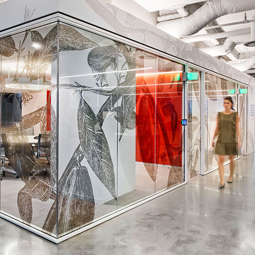 A person standing next to a glass display case with a painting.