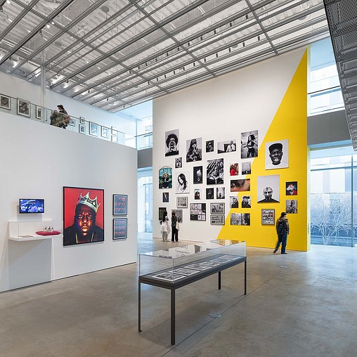 A large room with a large yellow sign and people walking around.