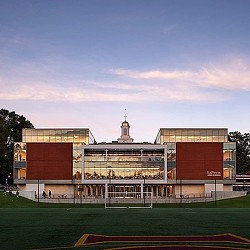 A large building with a field in front of it.