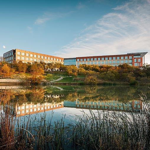 A building with a pond in front of it.