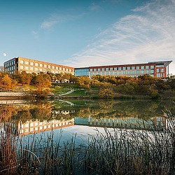 A building with a pond in front of it.