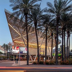 A building with palm trees in front of it.