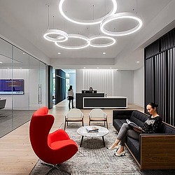 A person sitting on a couch in a room with a large glass wall.