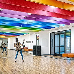 A couple of people walking in a room with colorful lights.