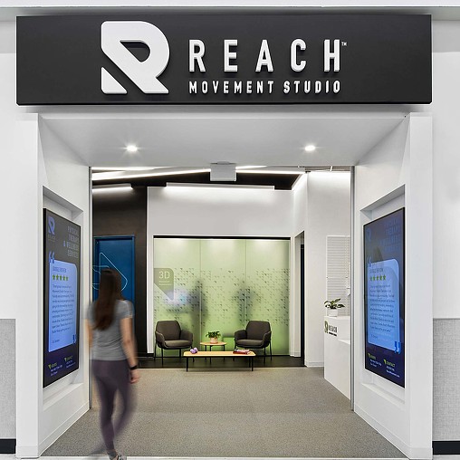 A woman walking into Reach Movement Studio.