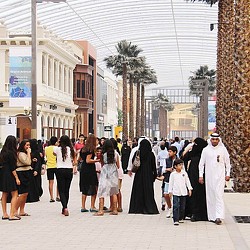 A group of people walking on a sidewalk.