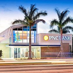 A building with palm trees in front.