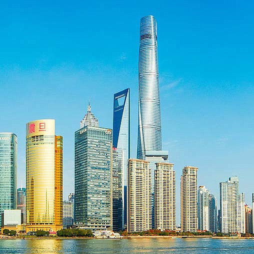 A group of tall buildings by the water.
