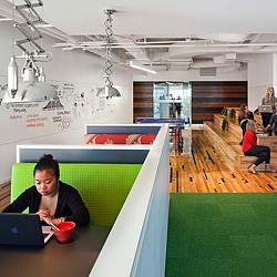 A person sitting at a table with a pool table and a pool table.