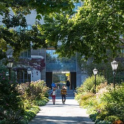 People walking on a path in front of a building.