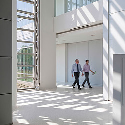 A couple of men walking in a building.